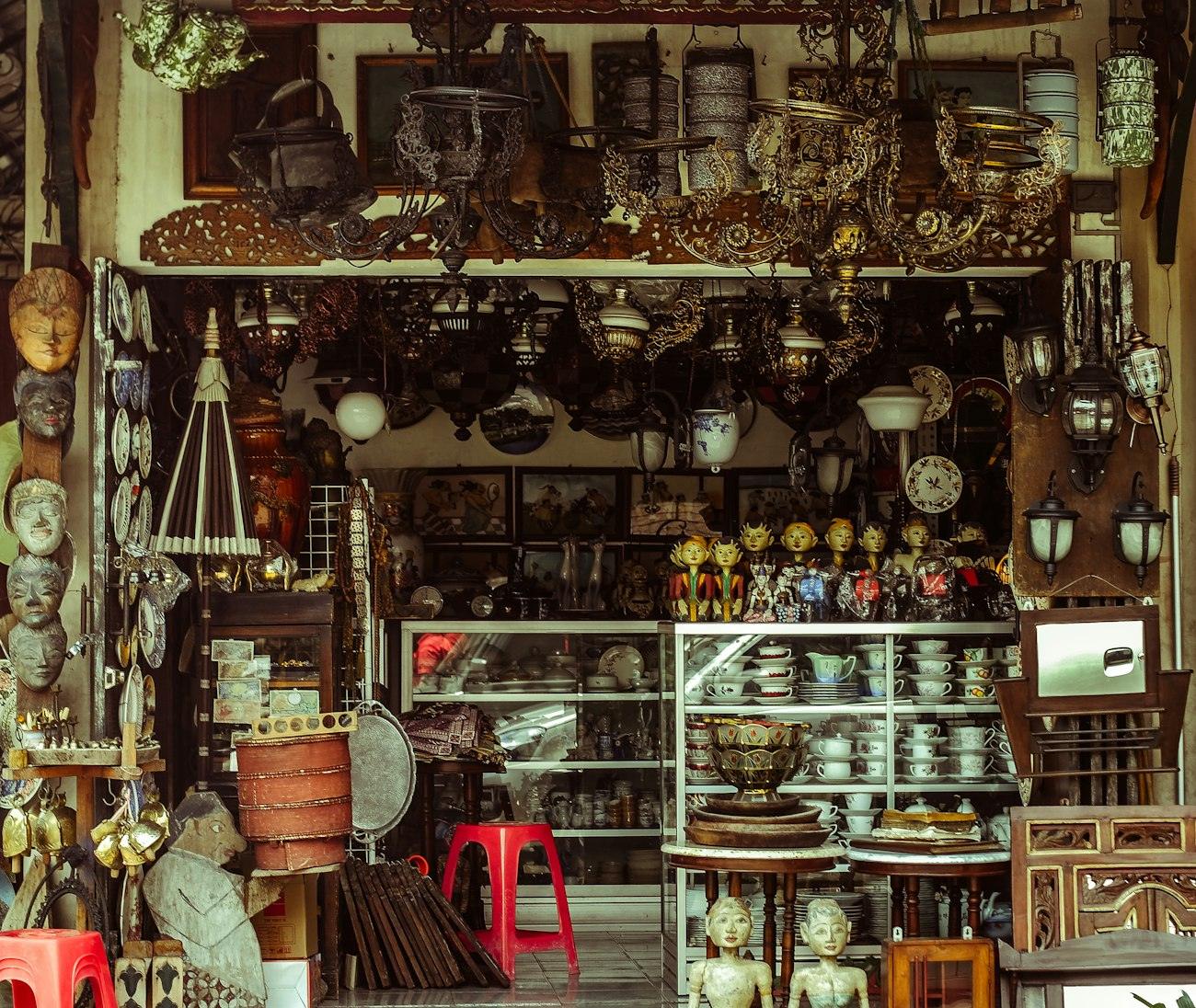 Brass, frames and ceramics crowded on the shelves of an antique dealer