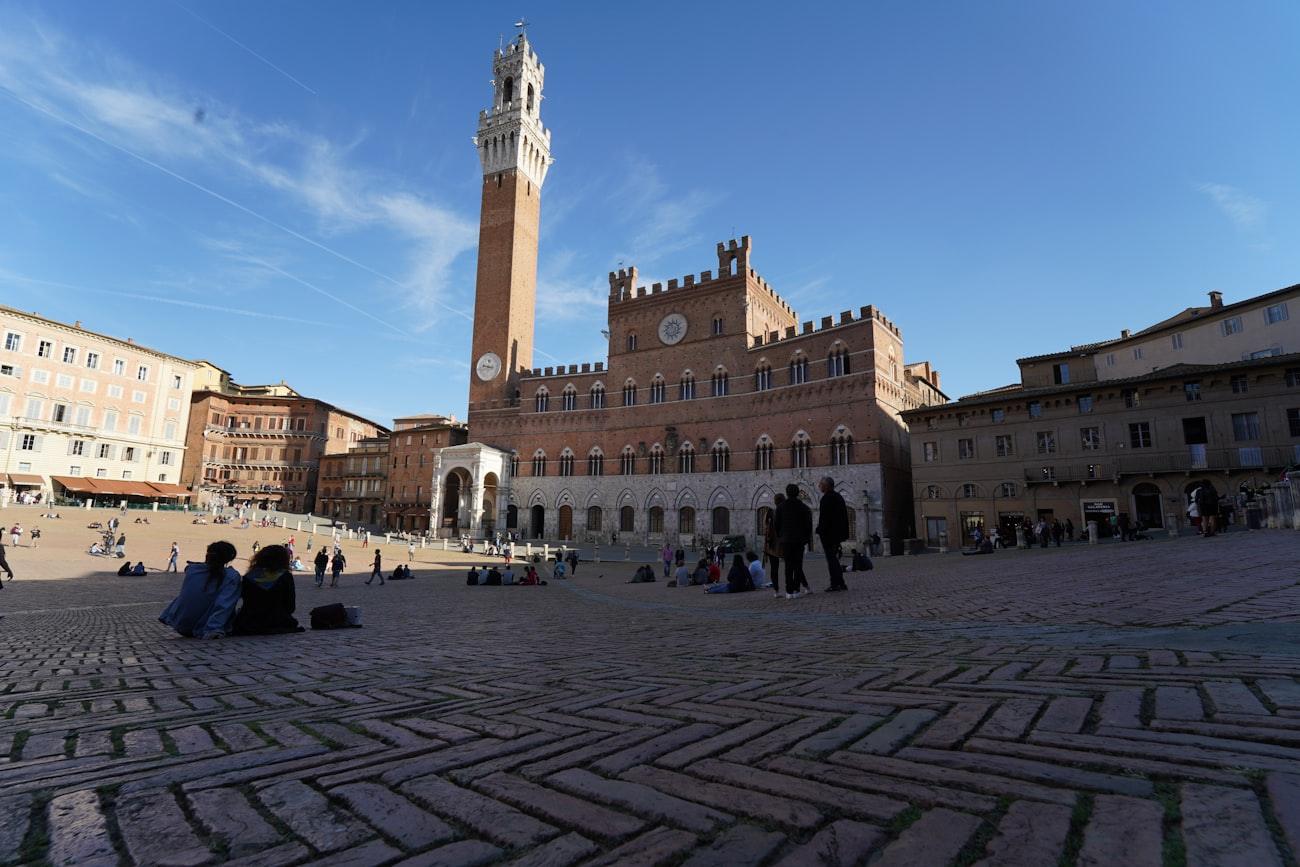 The sloping brick shell of Piazza del Campo with the tower above it